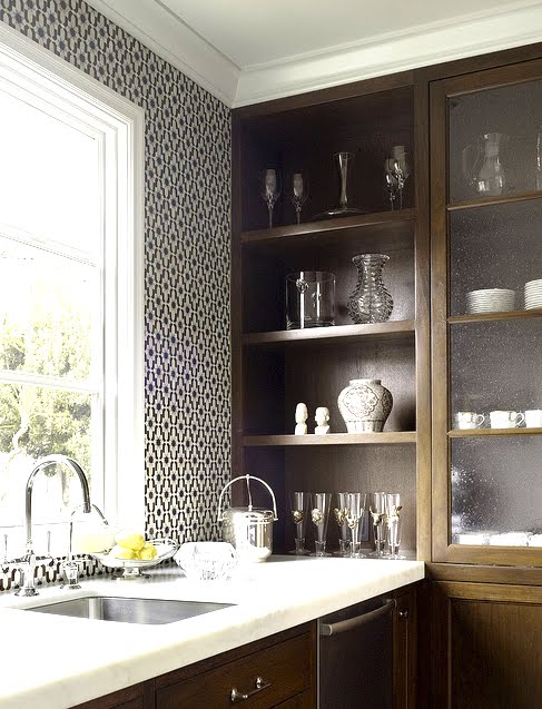 Close up of a kitchen with black and white Moroccan tiles, wood cabinets and white marble counter tops by House of Fifty