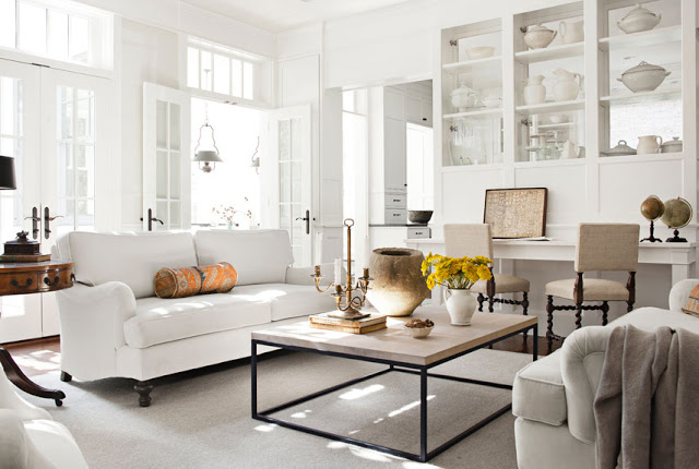 White living room with dueling sofas, turned wood chairs, french doors and ironstone dishware in the built in shelving