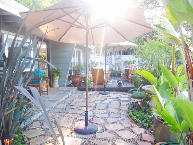 Backyard Garden with a stone pathway and umbrellas