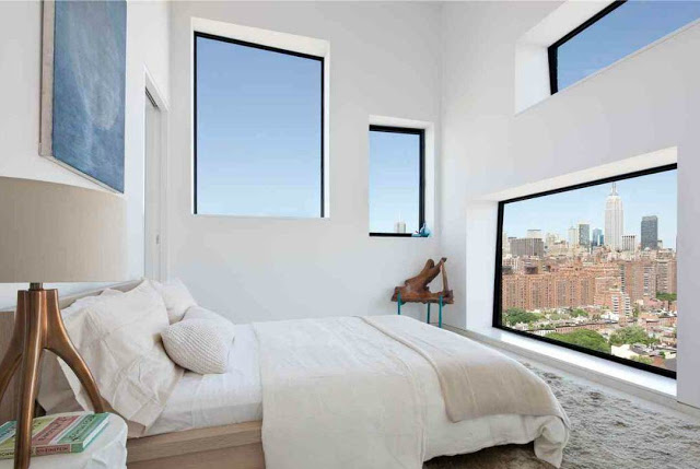 small guest bedroom with shag rug and a view of the NYC at the foot of the bed