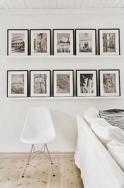 White living room with framed black and white photos on floating shelves
