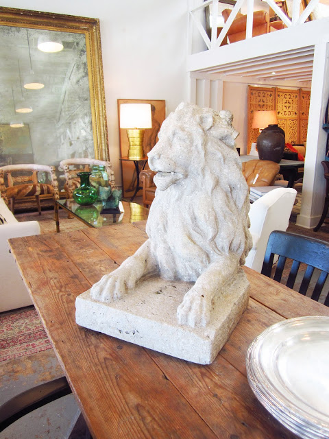 stone lion statute on a wood table inside Brenda Antin