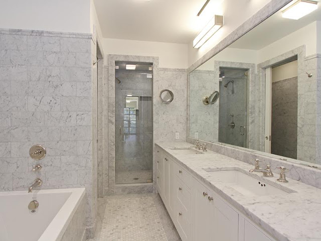 Master bathroom with Carara marble counter top and walls, deep step in tub and white cabinets