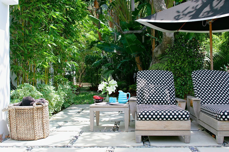 Outdoor patio with polka dot chaise lounge cushions on teak lounge chairs