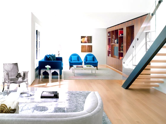 Open floor plan modern New York City blue armchairs sofa glass railing staircase
