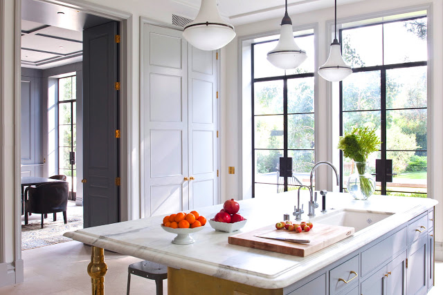 kitchen designed by William Hefner with panel doors, white cabinets and a yellow island with a marble countertop
