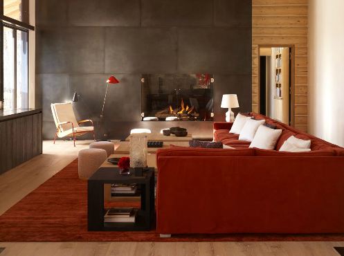 i2i jonn coolidge's rust and gray living room with burnt orange velvet sofa with white accent pillows and a modern sectional fireplace wall