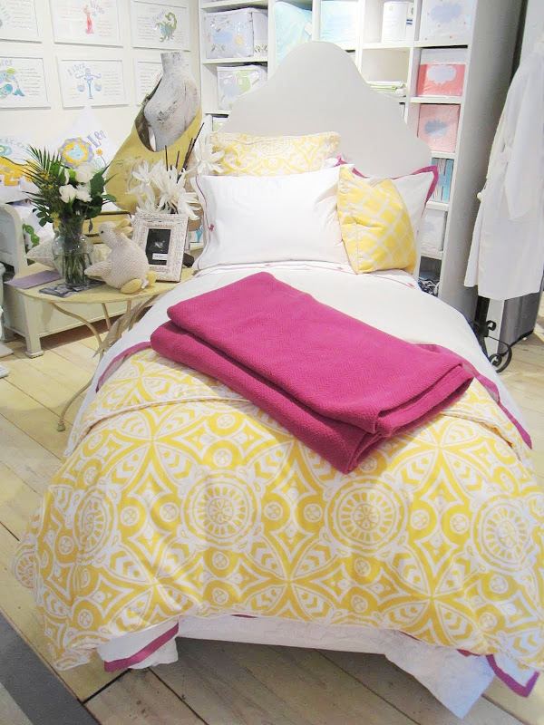 Twin bed by Serena & Lily with yellow graphic print duvet cover and pillows with a splash of fuchsia in the form of a throw and pillow and bed sheet trims