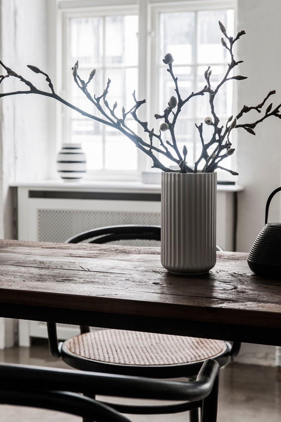 twigs branches in vase on dining room table small apartment
