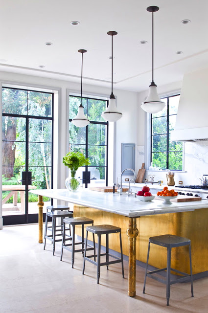 kitchen designed by William Hefner with glass doors, gray stools and yellow island with white marble countertop