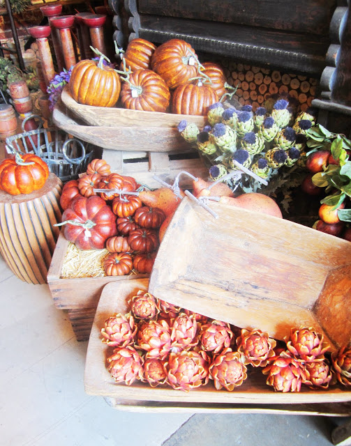 Fesitval fall arrangement with pumpkins, artichoke, other fall vegetables and wood trays
