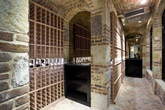 wine cellar with brick walls, wooden racks and brick herringbone floor
