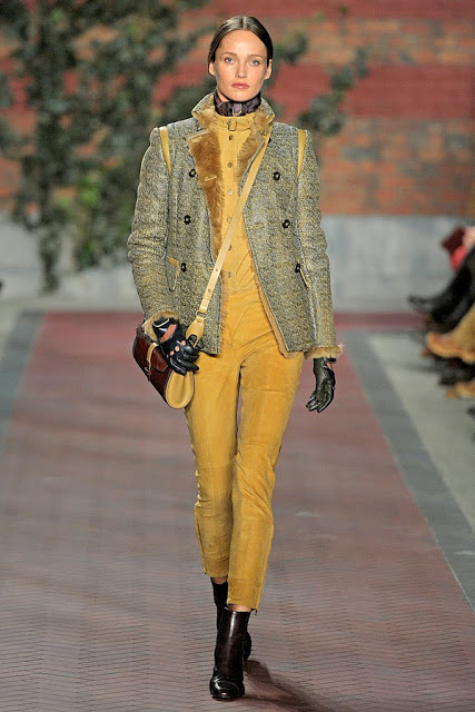 model from tommy hilfiger's fall 2012 runway show wearing mustard yellow pants, a fur lined jacket and boots