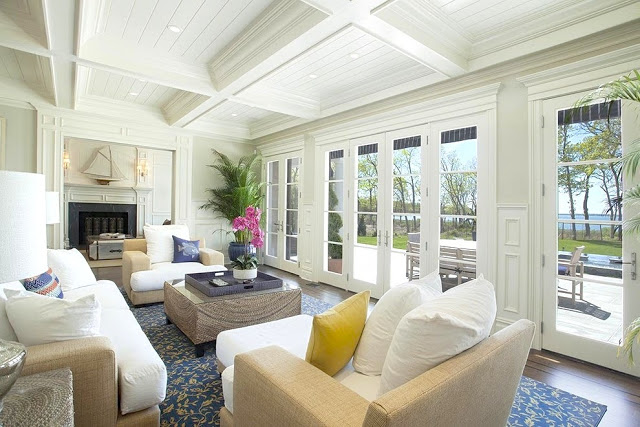 Living room Sag Harbor home French doors coffered ceiling fireplace wicker furniture