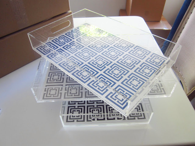 Two black and one blue COCOCOZY Logo Lucite Trays being packed for shipping