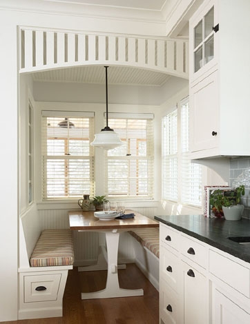 rehkamp larson architects' breakfast nook with booth banquette style bench seating, a wooden table with white legs, pendant light and built in wood slat ceiling