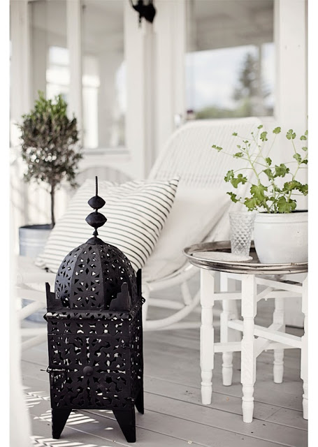 Black Moroccan lantern lamp on a grey front porch