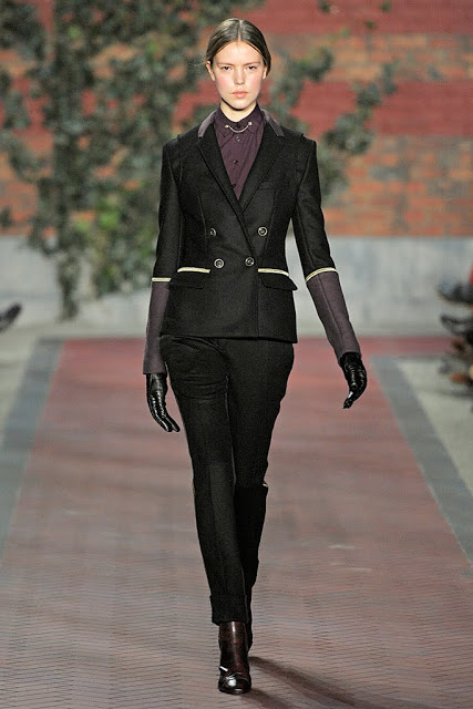 model from tommy hilfiger's fall rtw 2012 wearomg a black suit with trim piping