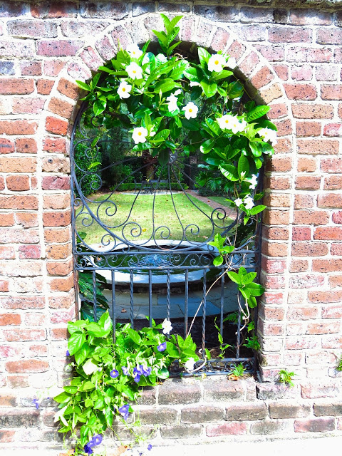 Brick arch and wrought iron garden gate window in Charleston, South Carolina