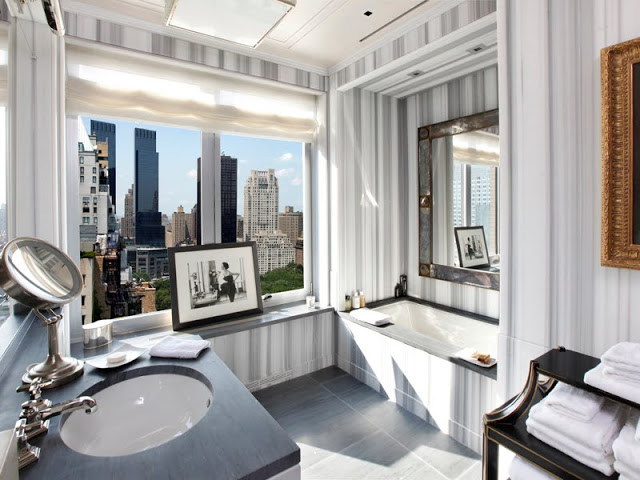 master bathroom with step in tub, window with a view of Central Park, black counter tops and striped marble walls