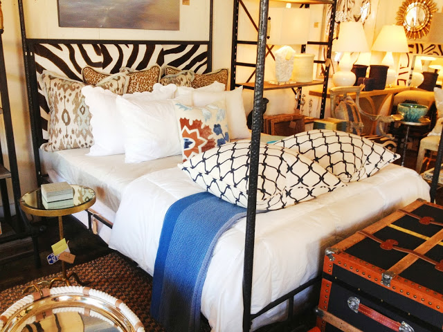 COCOCOZY Fence pillows in Navy on an iron canopy bed with a zebra print headboard at Mecox Gardens in Los Angeles, CA