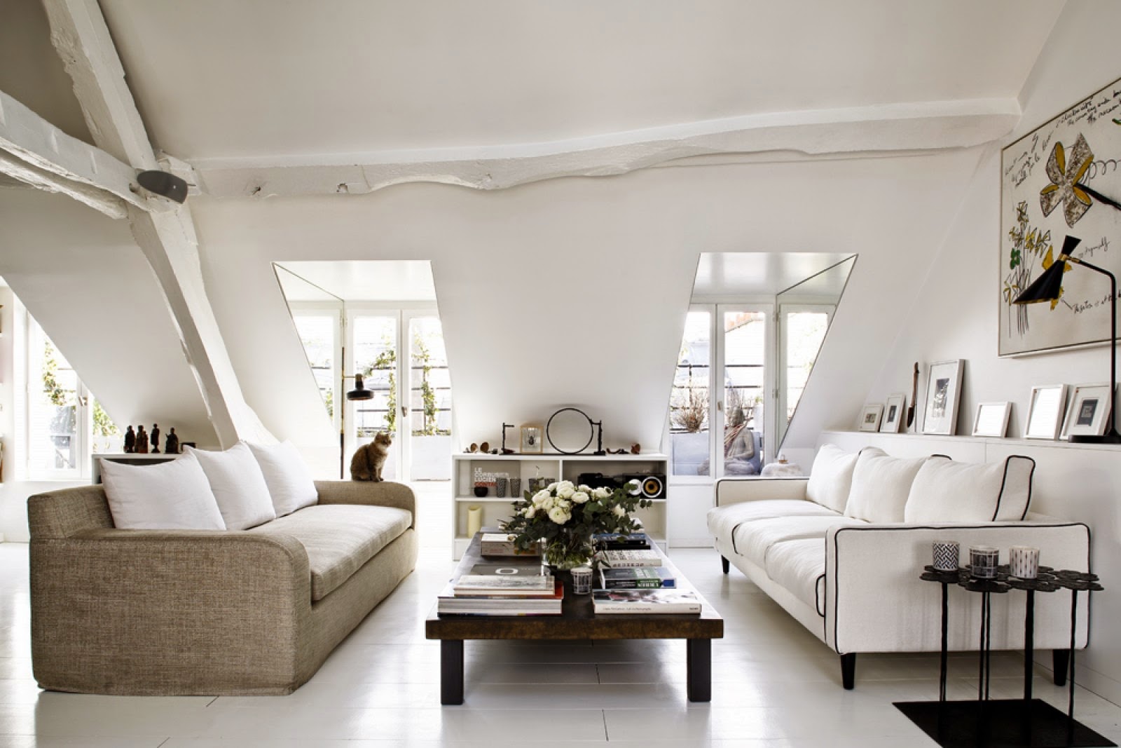 Living room in a Paris attic apartment with dueling sofas and yellow and black accents
