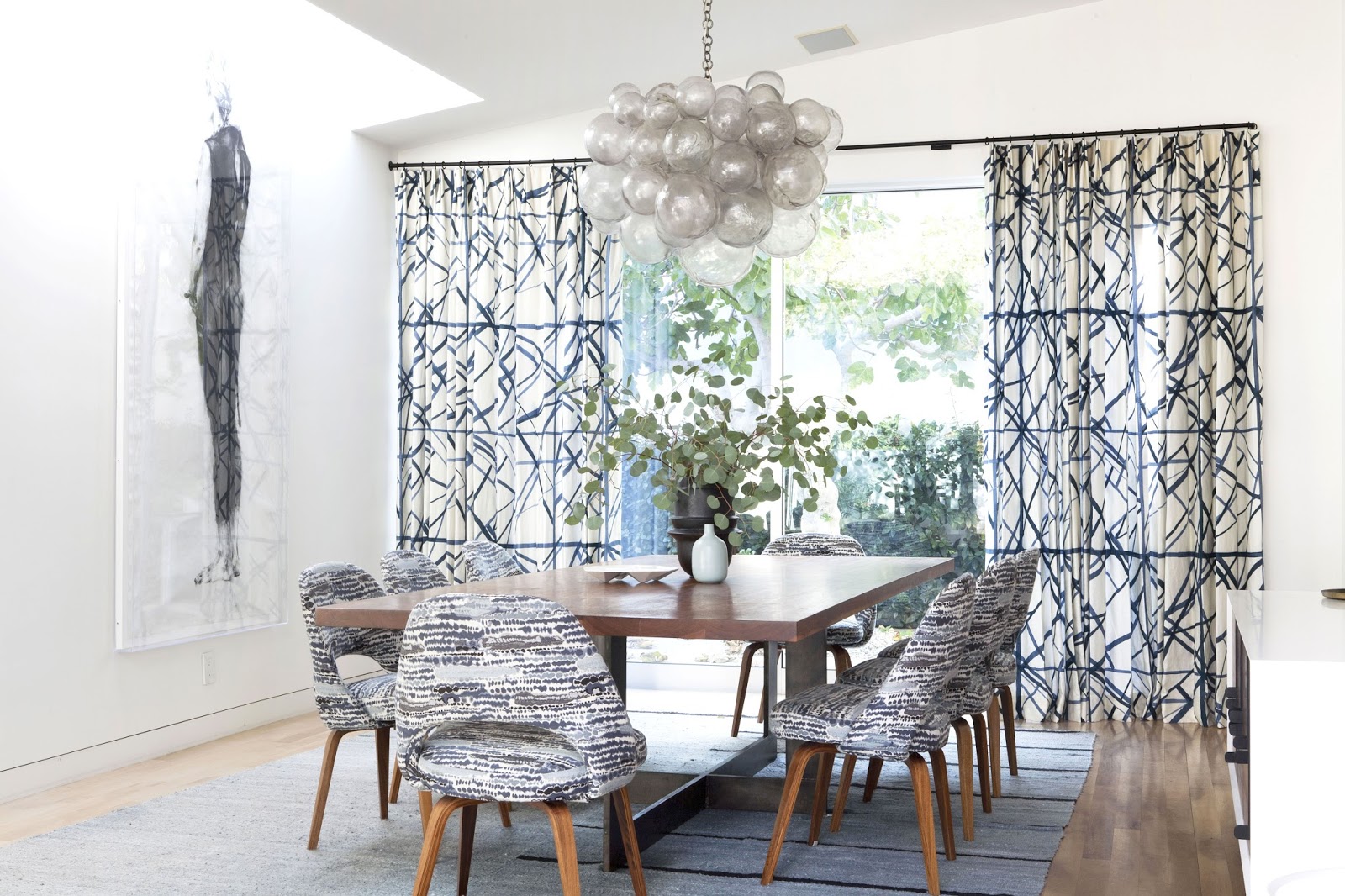 Dining room with bubble chadelier and graphic printed curtains and chairs