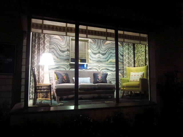 harbinger window display with wave wallpaper, velvet sofa, COCOCOzy quatrefoil curtains in gray reverse and a green armchair