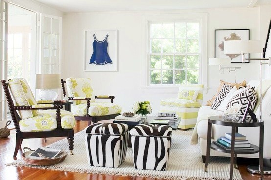 beach cottage with chic zebra print ottoman, graphic floral upholstery arm chairs and a white sofa with graphic accent pillows, a wood floor and a white rug