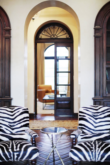 Close up of the zebra print chairs in a living room with herringbone wood parquet floors and neutral furnishings