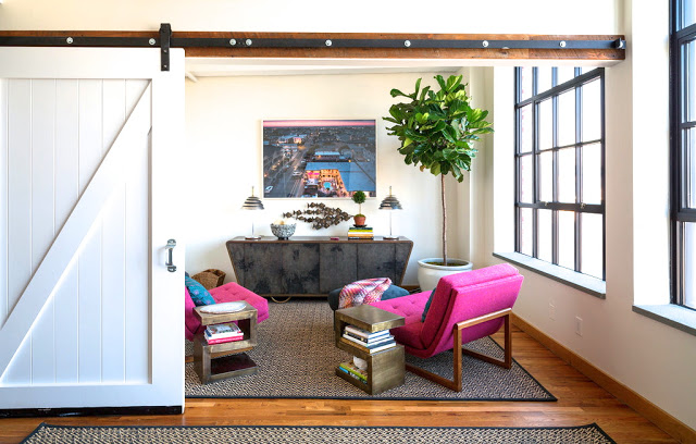 Anne Maxwell's nyc loft apartment den with pink lawson fenning chairs, wood floors, and a barn door