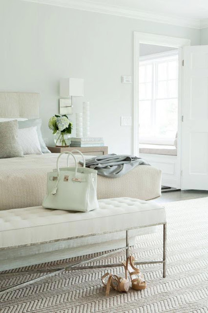 Pastel bedroom with an upholstered headboard, Chevron carpet with a Hermes Birkin on the white tufted bench