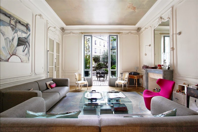 Den in a Paris townhouse with a bright pink chair