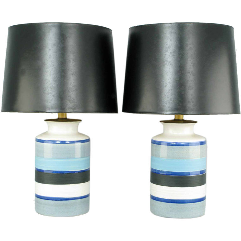 Two vintage table lamps have hand thrown pottery bodies, blue and black glazed horizontal stripes on a white ground and black shades