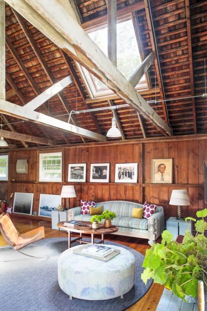 Living room with exposed beams and stained wood walls