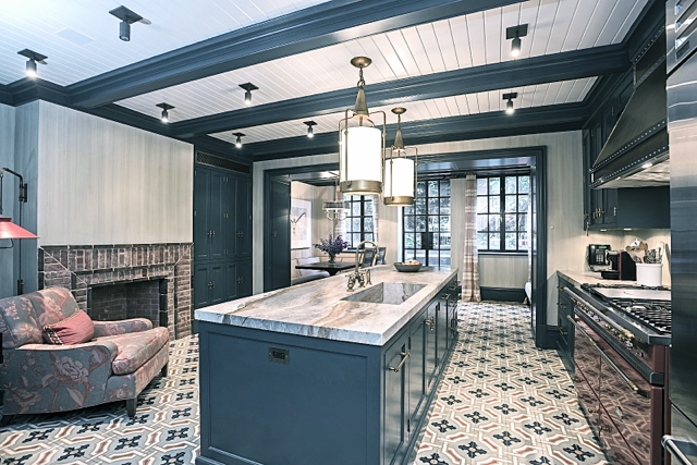 Blue and grey kitchen with brick fireplace and marble countertops in Steven Gambrel's home
