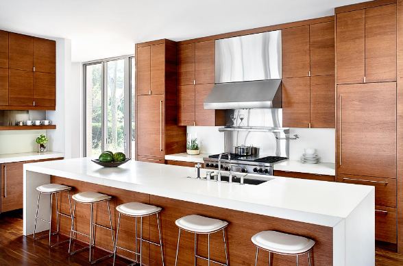 modern kitchen with wood cabinets, white caesar stone counters and white barstools