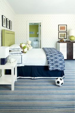 Boys bedroom with lime green upholstered headboard, striped carpet and white and wood chest of drawers