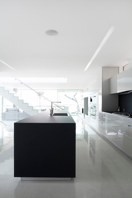 Modern white kitchen in the Flip Flop House with a black island