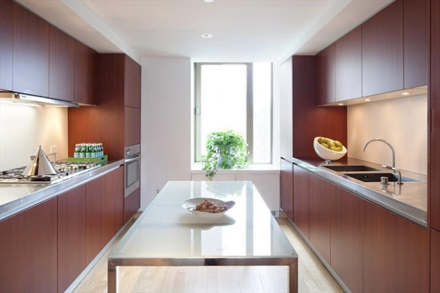 modern kitchen in a New York City penthouse with wood veneer cabinets and metal table island 
