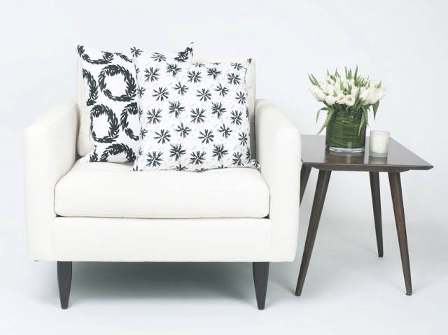 COCOCOZY Light pillows in Rive and Etoile in black and white with a wooden accent table holding tulips and a white candle