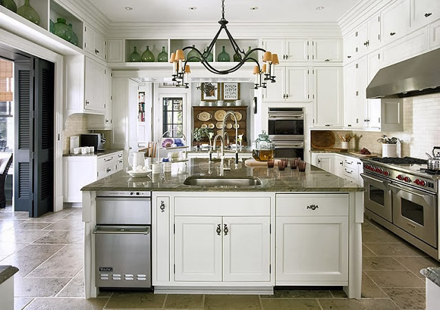 Large Kitchen in a South Carolina estate with stainless appliances, white cabinets and drawers and a metal chandelier