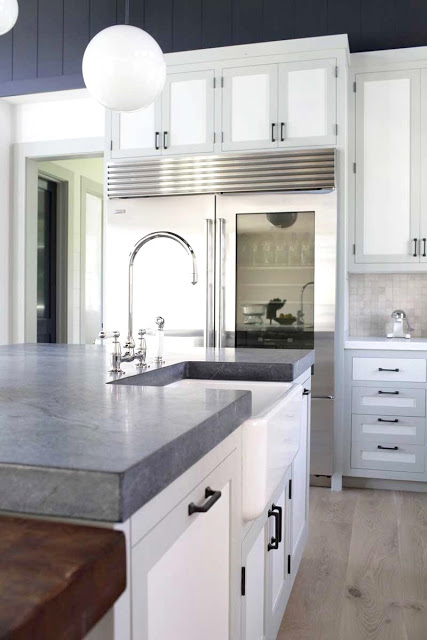 Kitchen island with grey soapstone counters and white cabinets