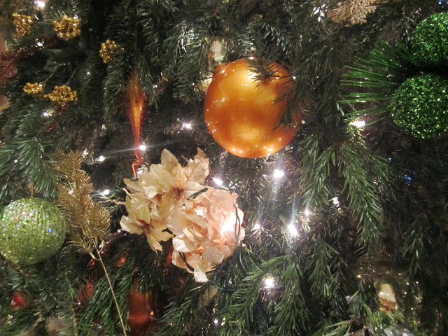 close up of a Christmas tree with green and gold ornaments
