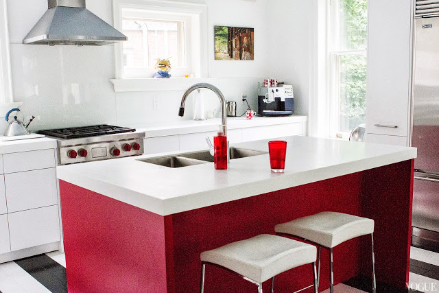 Kitchen in Vogue.com contributorSophie Young's childhood home with black and white striped floor, red island and stainless appliances