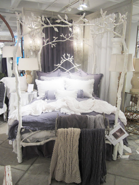 Metal bed frame painted white to look like birch trees by Corsican with chunky purple and white knit throws and matching bedding