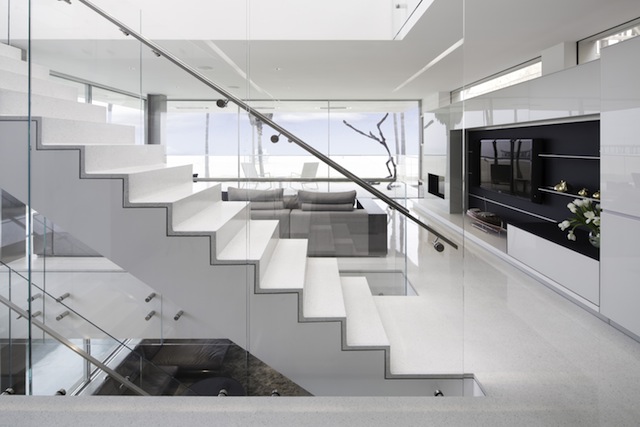 Modern staircase in the Flip Flop House with glass rail and Terrazzo covered floor
