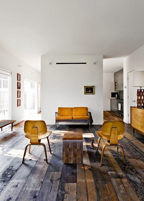 Modern living room with yellow chairs and rustic wood floor