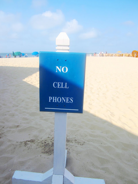 white sign post with blue sign on a beach
