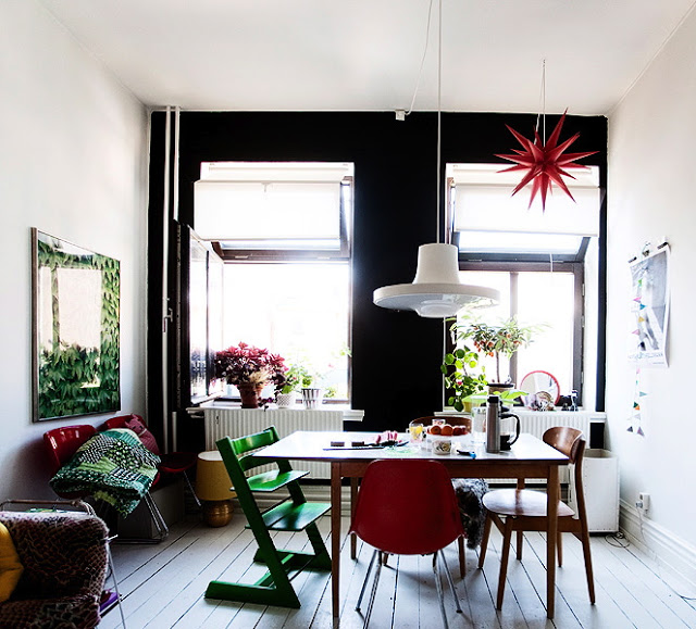 Sweden Swedish dining room black painted feature wall white pendant light table chairs red green white wood floors